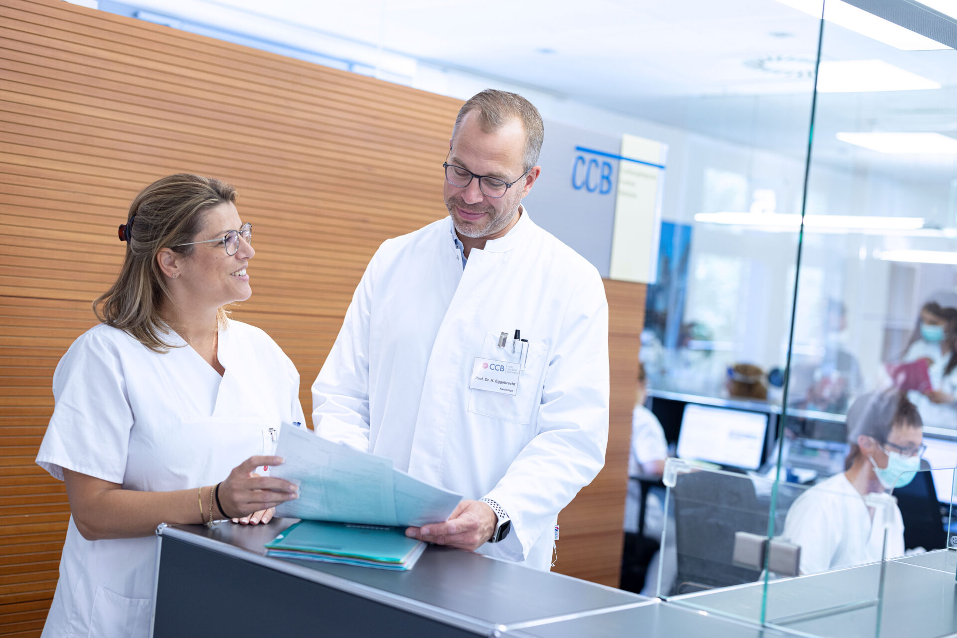 Arzt bespricht sich mit Medizinischem Fachpersonal am Empfang